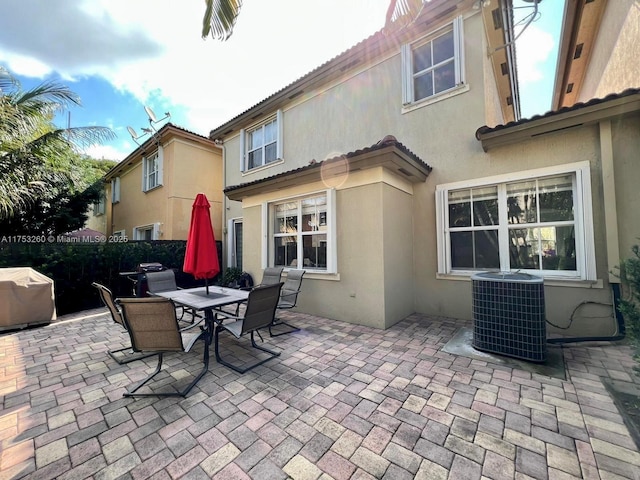 view of patio with central AC, outdoor dining area, area for grilling, and fence