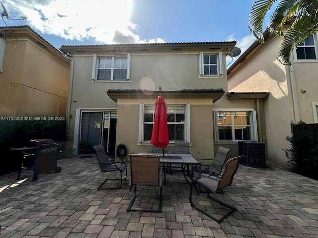 back of house with a patio, central AC unit, and stucco siding