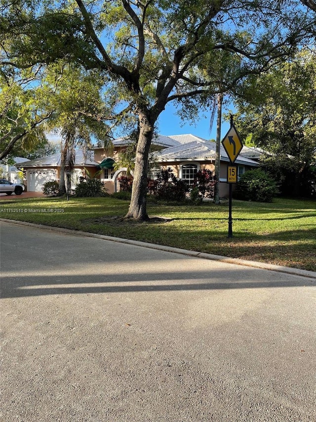 view of front of property with a garage, driveway, and a front yard