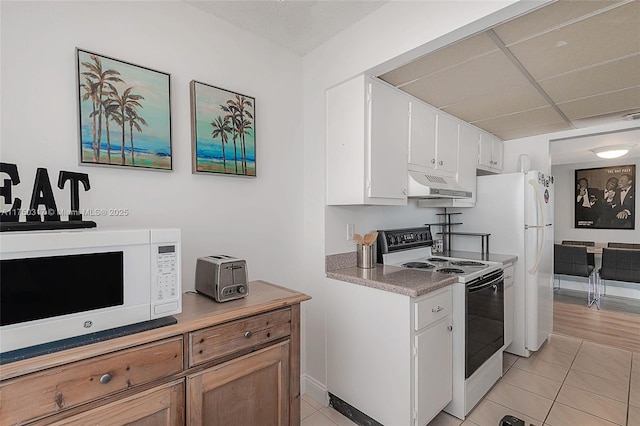 777 S Federal Hwy Unit Rp817, Pompano Beach, FL 33062 - kitchen featuring electric stove, white microwave, under cabinet range hood, light tile patterned floors, and light countertops