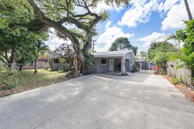 ranch-style house with driveway, fence, a gate, and stucco siding