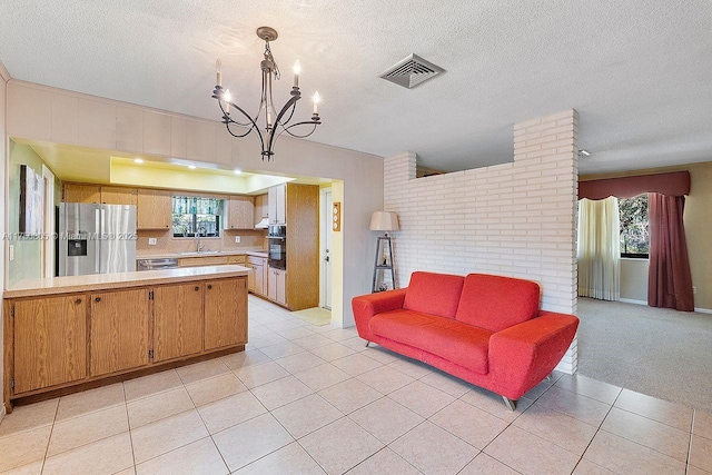 kitchen featuring visible vents, stainless steel appliances, light countertops, a sink, and light tile patterned flooring