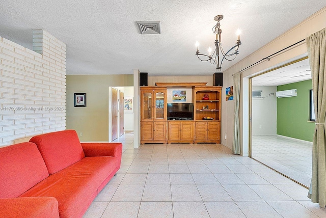 living area with a textured ceiling, visible vents, an AC wall unit, and light tile patterned flooring