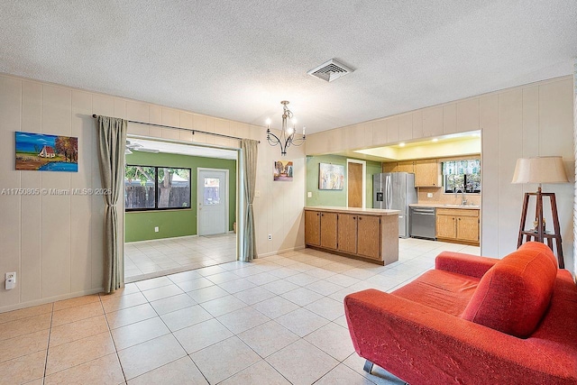 living area with light tile patterned floors, a chandelier, visible vents, and a healthy amount of sunlight