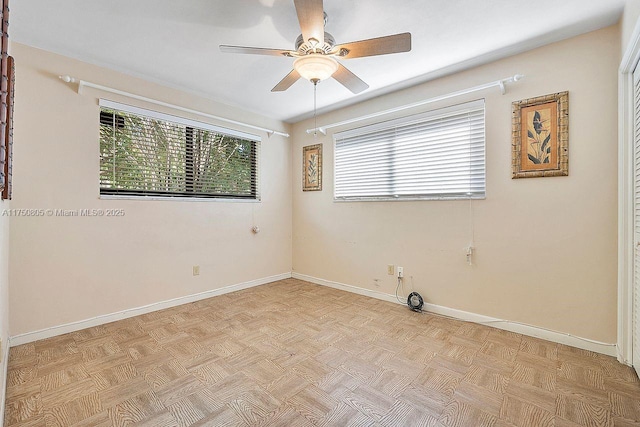 unfurnished room with a ceiling fan and baseboards