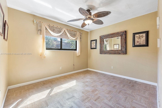 unfurnished room with ceiling fan and baseboards