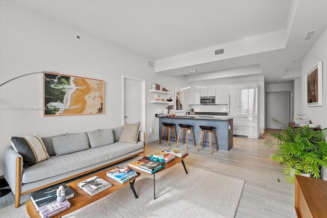 living area with light wood-type flooring and visible vents