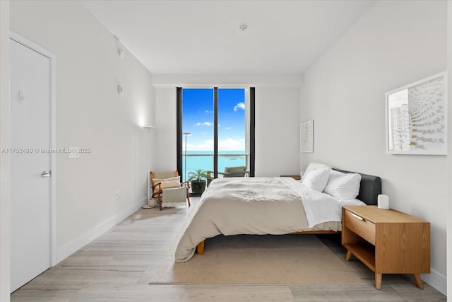 bedroom with light wood-style floors and baseboards