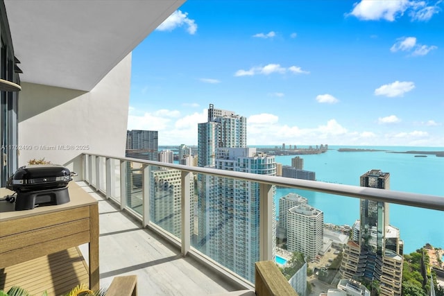 balcony featuring a water view, a grill, and a city view