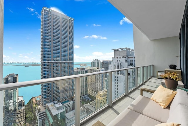 balcony with a water view and a view of city