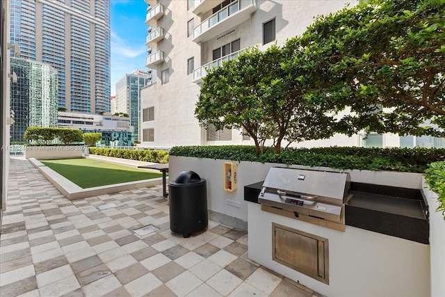 view of patio / terrace featuring a view of city, grilling area, and exterior kitchen