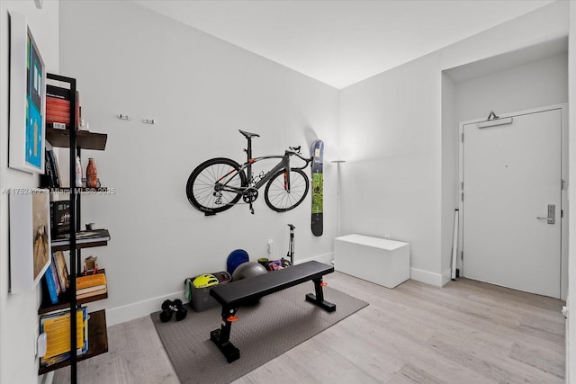 workout room featuring baseboards and wood finished floors