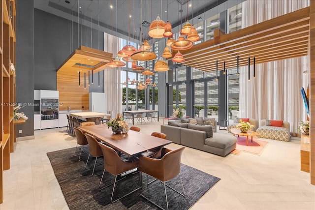 dining space featuring expansive windows, a high ceiling, and a notable chandelier