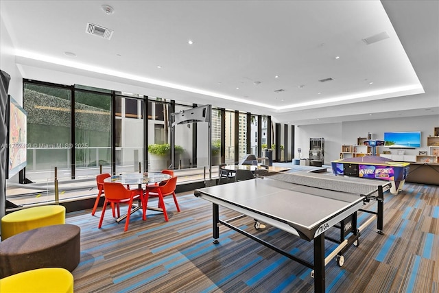 rec room featuring a raised ceiling, carpet flooring, and visible vents