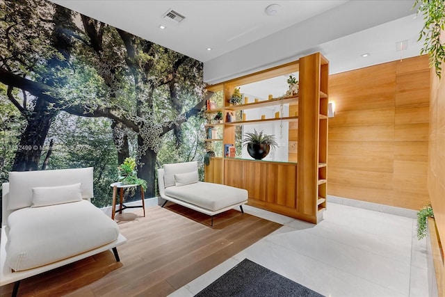 sitting room with wood finished floors, visible vents, and floor to ceiling windows