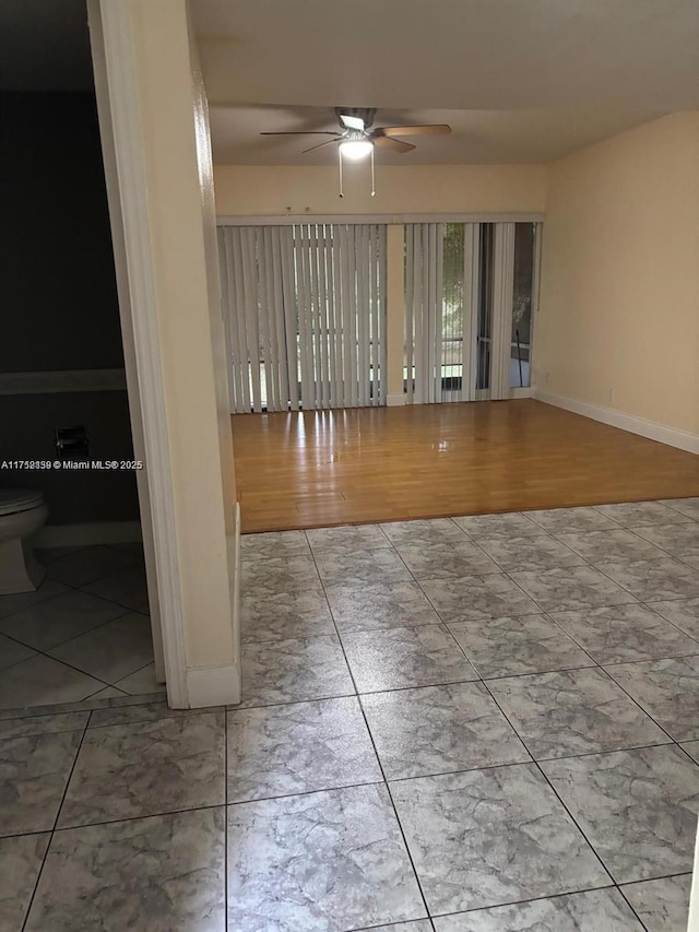 spare room featuring baseboards and ceiling fan