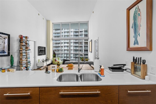 475 Brickell Ave Unit 2809, Miami, FL 33131 - kitchen with a sink, light countertops, brown cabinetry, and expansive windows