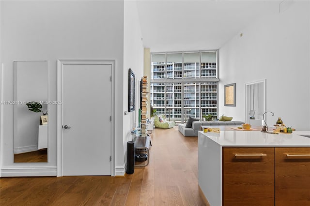 interior space featuring a towering ceiling, expansive windows, and wood finished floors