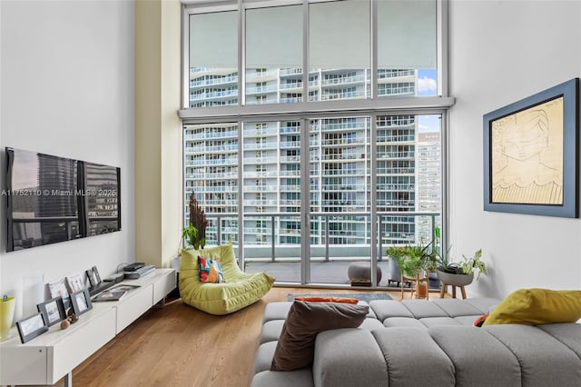 living area featuring expansive windows, a high ceiling, and wood finished floors