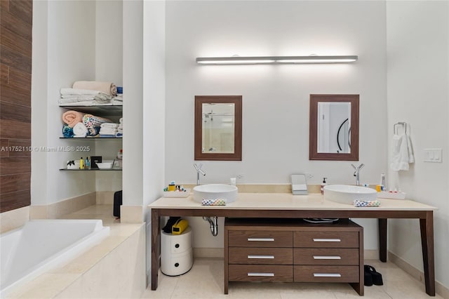 bathroom with double vanity, tiled tub, a sink, and tile patterned floors