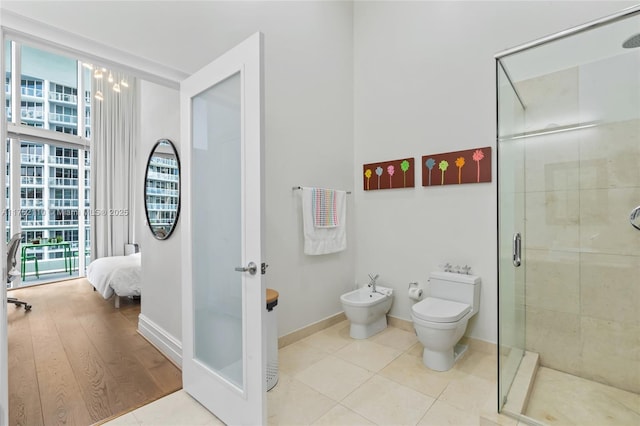 full bathroom with tile patterned flooring, toilet, baseboards, a shower stall, and a bidet