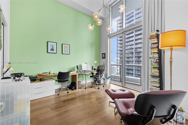 office space featuring a high ceiling, wood finished floors, and baseboards