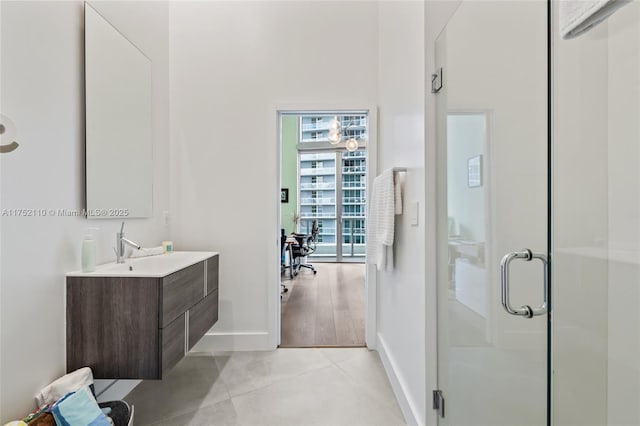 full bath featuring tile patterned floors, a shower stall, vanity, and baseboards