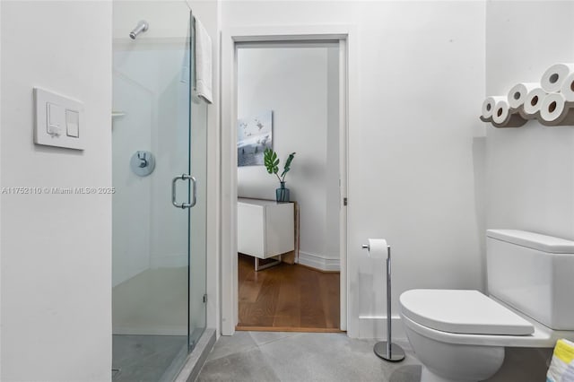 bathroom featuring toilet and a stall shower