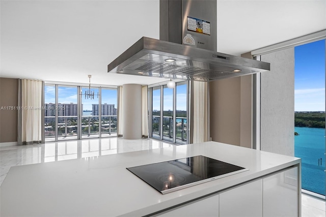 kitchen with expansive windows, island exhaust hood, white cabinets, and black electric cooktop