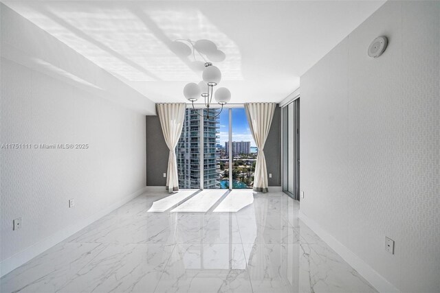 300 Sunny Isles Blvd Unit 4-1208, Sunny Isles Beach, FL 33160 - empty room featuring floor to ceiling windows, a chandelier, marble finish floors, a city view, and a smoke detector