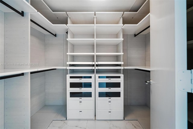 walk in closet featuring marble finish floor