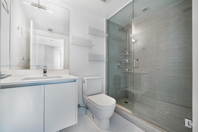 bathroom with visible vents, toilet, a stall shower, vanity, and tile patterned floors