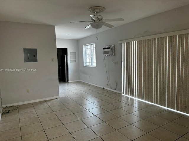 spare room featuring light tile patterned floors, ceiling fan, a wall mounted air conditioner, electric panel, and baseboards