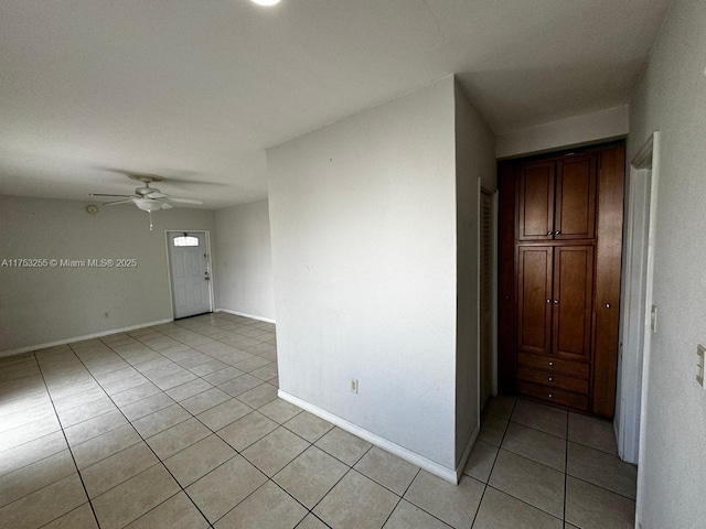 unfurnished room featuring light tile patterned floors, baseboards, and a ceiling fan