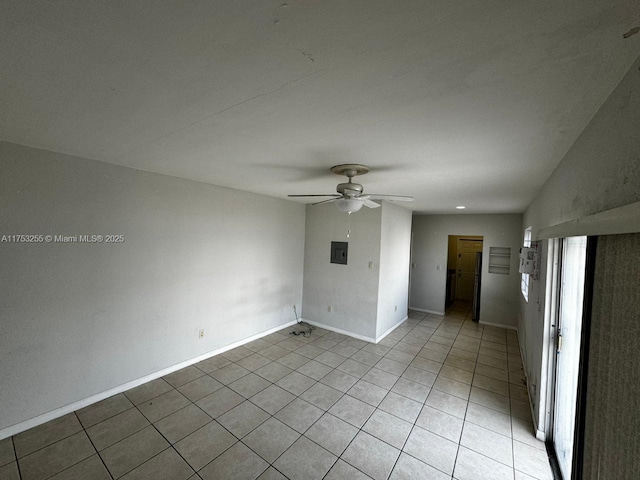 spare room with light tile patterned floors, a ceiling fan, and baseboards