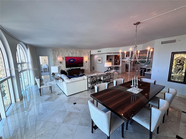 dining area featuring marble finish floor, visible vents, and an inviting chandelier