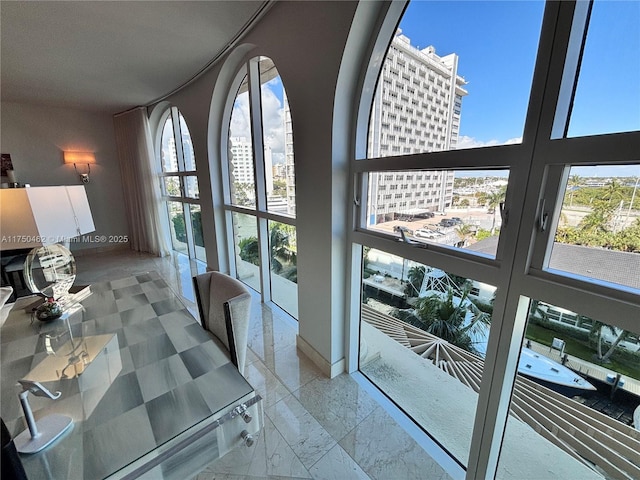 interior space featuring baseboards, marble finish floor, and a city view