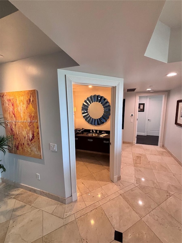 hall with marble finish floor, visible vents, and baseboards