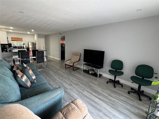 living area featuring light wood finished floors, baseboards, and recessed lighting