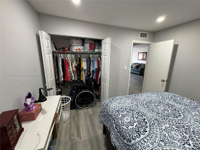 bedroom featuring a closet, visible vents, and wood finished floors