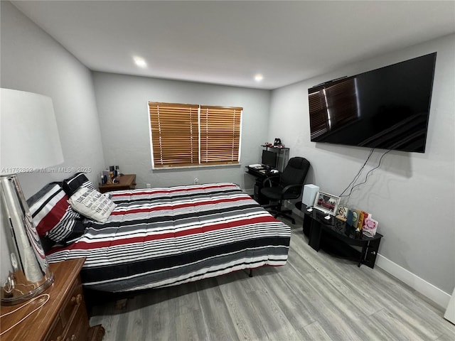 bedroom with recessed lighting, wood finished floors, and baseboards