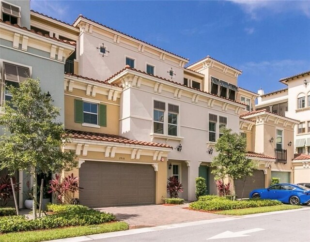 2910 NW 124th Way Unit 2910, Sunrise, FL 33323 - view of front of house featuring stucco siding, a garage, a tiled roof, and decorative driveway