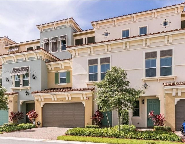 2910 NW 124th Way Unit 2910, Sunrise, FL 33323 - view of front facade featuring stucco siding, an attached garage, decorative driveway, and a tiled roof