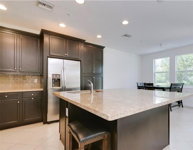 2910 NW 124th Way Unit 2910, Sunrise, FL 33323 - kitchen featuring stainless steel fridge with ice dispenser, light tile patterned floors, recessed lighting, backsplash, and light stone counters
