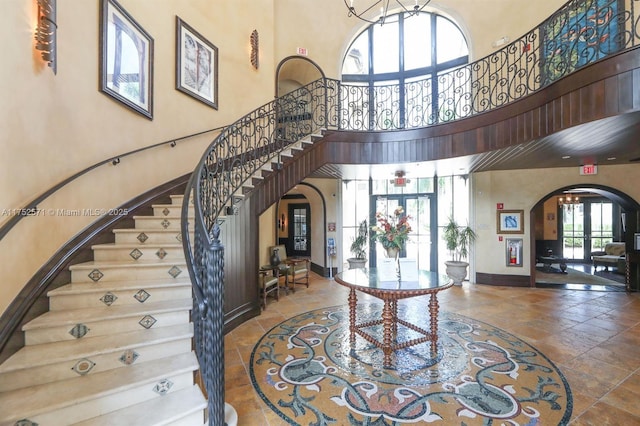 2910 NW 124th Way Unit 2910, Sunrise, FL 33323 - foyer with arched walkways, a towering ceiling, stairway, baseboards, and french doors