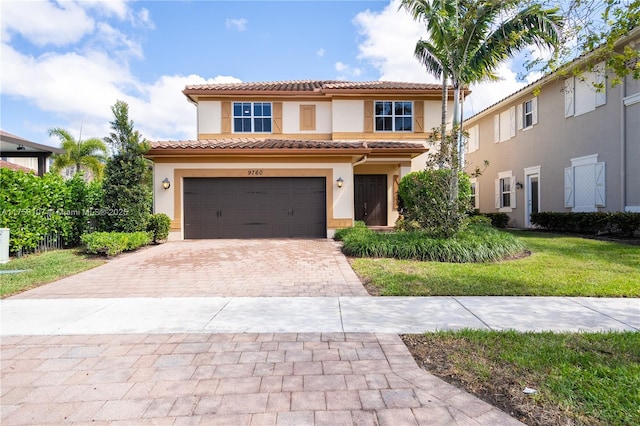 mediterranean / spanish home featuring a garage, a tile roof, decorative driveway, and stucco siding