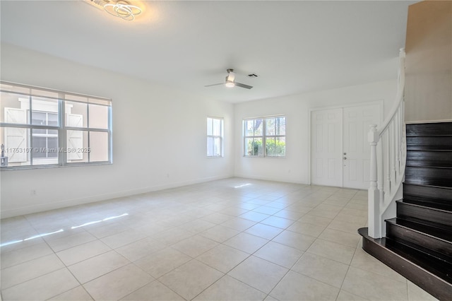 interior space featuring baseboards, visible vents, ceiling fan, stairs, and light tile patterned flooring