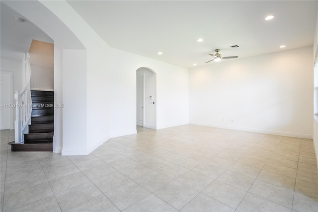 unfurnished room featuring arched walkways, baseboards, ceiling fan, stairway, and recessed lighting