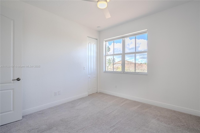 unfurnished room with light carpet, a ceiling fan, and baseboards