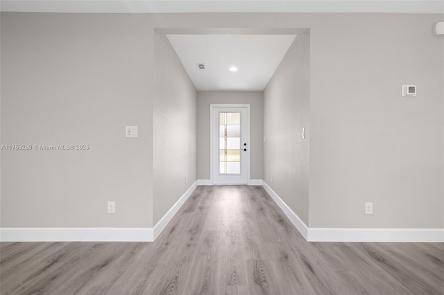 entryway with visible vents, light wood-style flooring, and baseboards